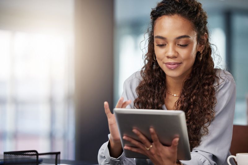 A woman uses a tablet focused on solving problems like Mailchimp emails going to spam.