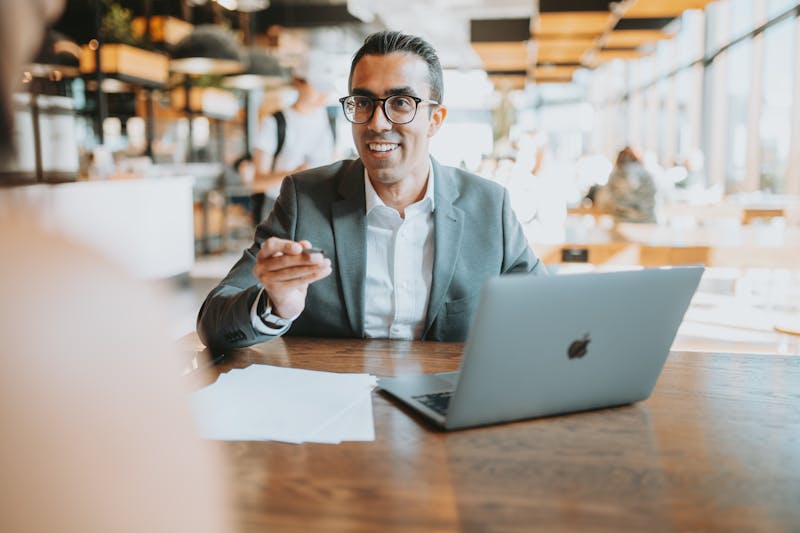 Man in glasses and suit smiling and discussing how to send mass emails 