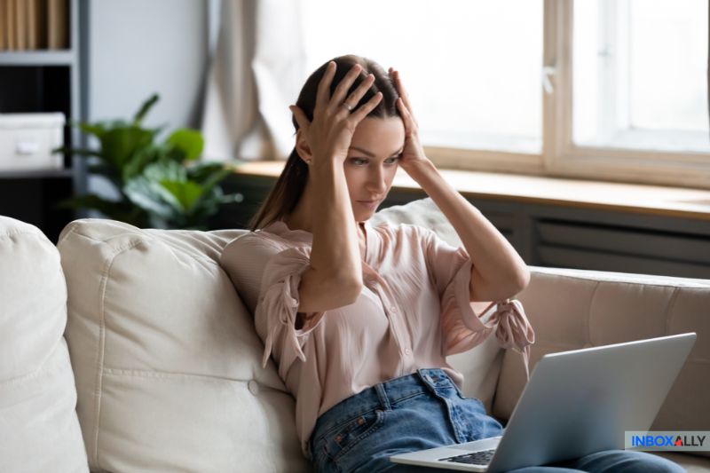 A frustrated woman looking at her laptop, trying to resolve the issue of "my emails are bouncing" quickly and effectively.