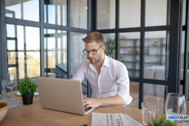 A focused man working on a laptop, troubleshooting the issue of "my emails are bouncing" to find a quick solution.