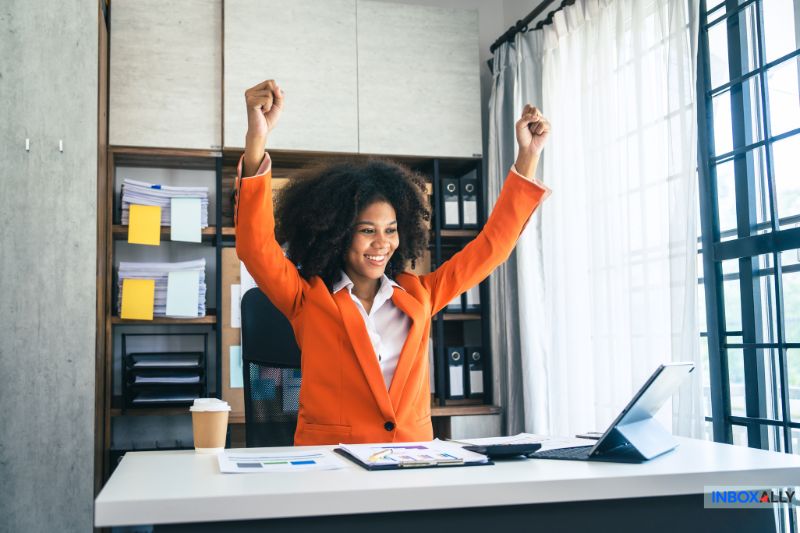 A joyful woman celebrating success after resolving the issue of "my emails are bouncing" and improving email deliverability.