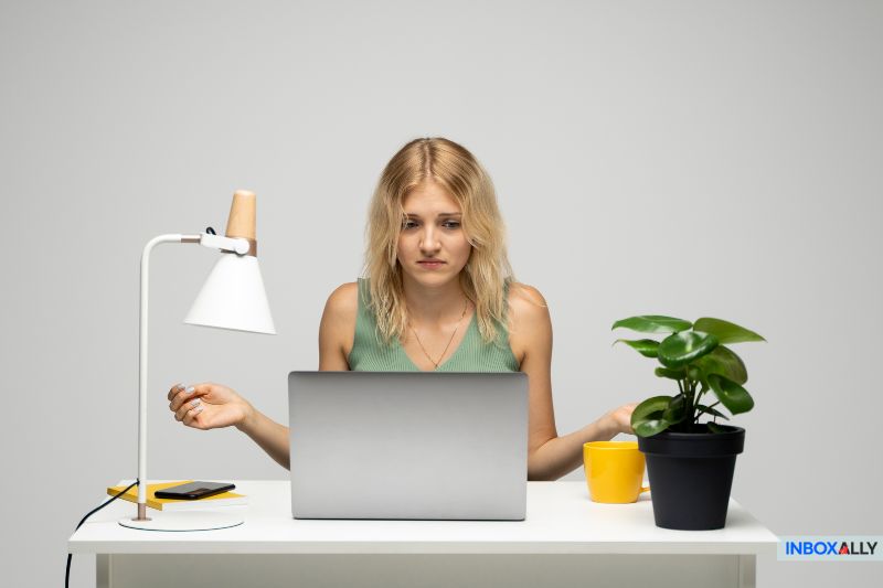 A frustrated woman looking at her laptop, wondering "why my emails are bouncing" and seeking quick troubleshooting tips.