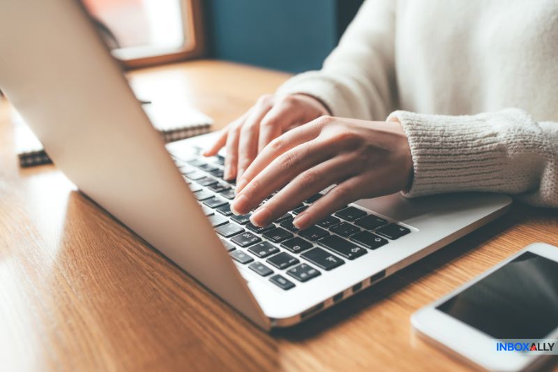 Close-up of hands typing on a laptop, illustrating email warm up techniques to enhance sender reputation and deliverability