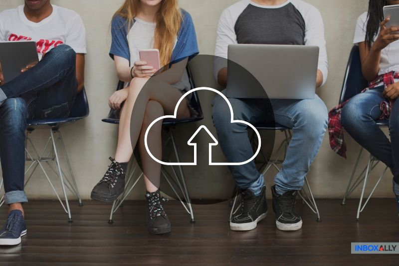 Young professionals using digital devices with cloud upload icon, symbolizing Google Workspace emails going to spam due to authentication issues.