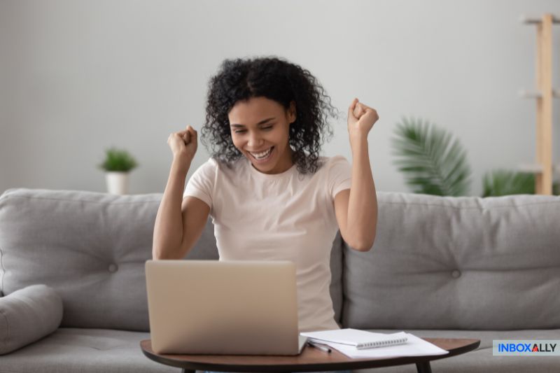 Happy woman celebrating email success, symbolizing a fix for 'message blocked Gmail' issues and improved email deliverability