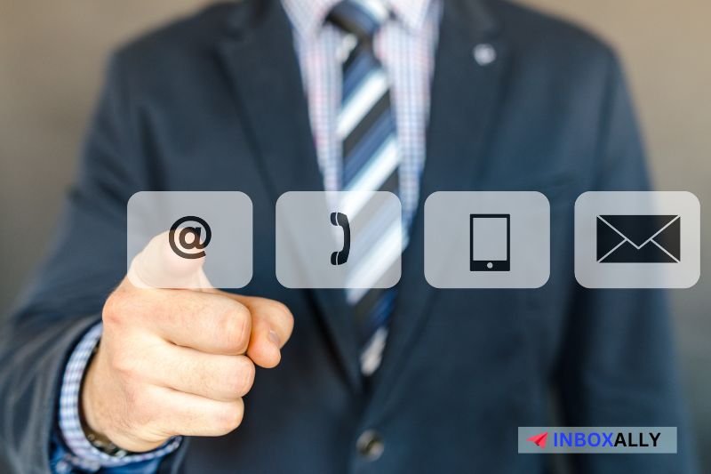 A suited person points at icons representing email, phone, mobile, and envelope highlighting the various communication channels ideal for sending a cold message or connecting through LinkedIn.