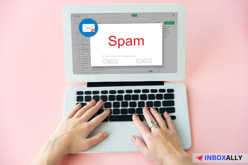 Hands typing on a laptop displaying a popup with the word "Spam" in red text helping prevent email traps and avoid email honeypots effectively.