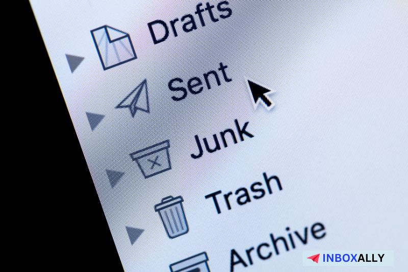 Close-up of an email application interface showing icons such as Drafts, Sent, Junk, Trash, and Archive with a cursor pointing at the Sent folder. The view highlights the email sent successfully notification.