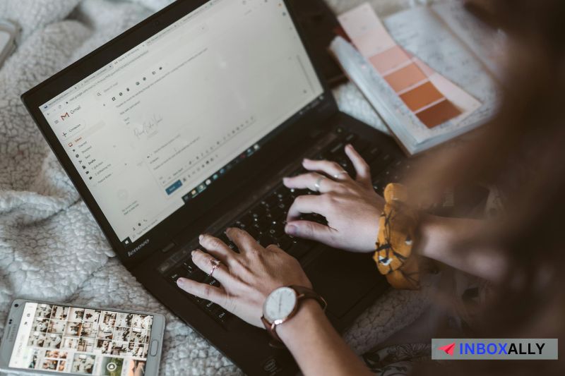 Person typing on a laptop with an email draft displayed crafting both HTML emails and plain text emails for 2024 campaigns.