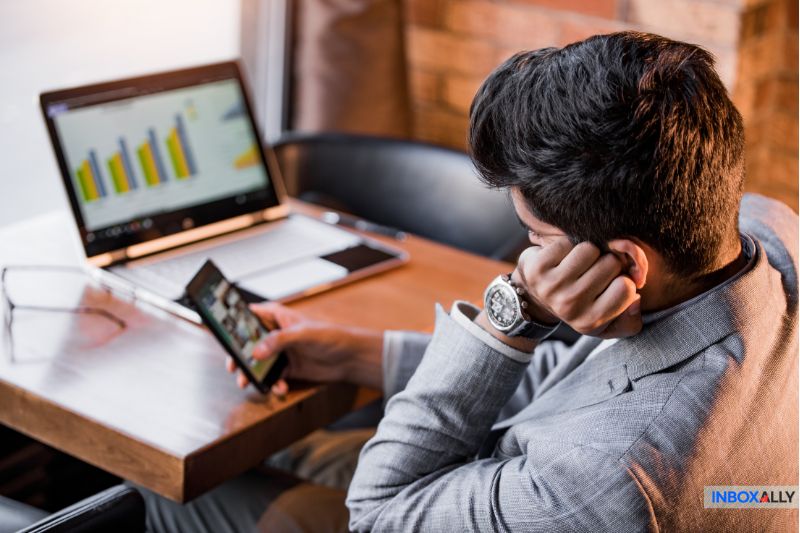 Businessman analyzing email performance metrics on a laptop, representing the challenges and effects of email throttling on deliverability.