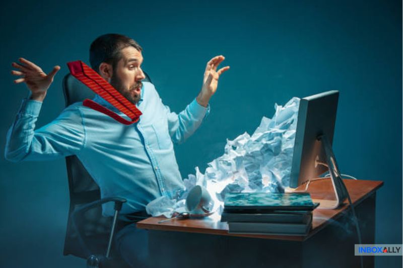 Man overwhelmed by a burst of paper from a computer, symbolizing email throttling challenges and its deliverability impact