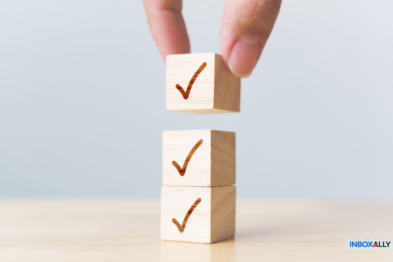 Mail merge advantages represented by stacked wooden blocks with checkmarks, symbolizing efficiency, accuracy, and automation in email campaigns